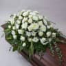Aranjament floral amplu așezat pe capacul sicriului