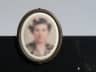 Medalion de fotoceramică oval (portret generic estompat, nedeslușit), ramă bronz, pe granit negru