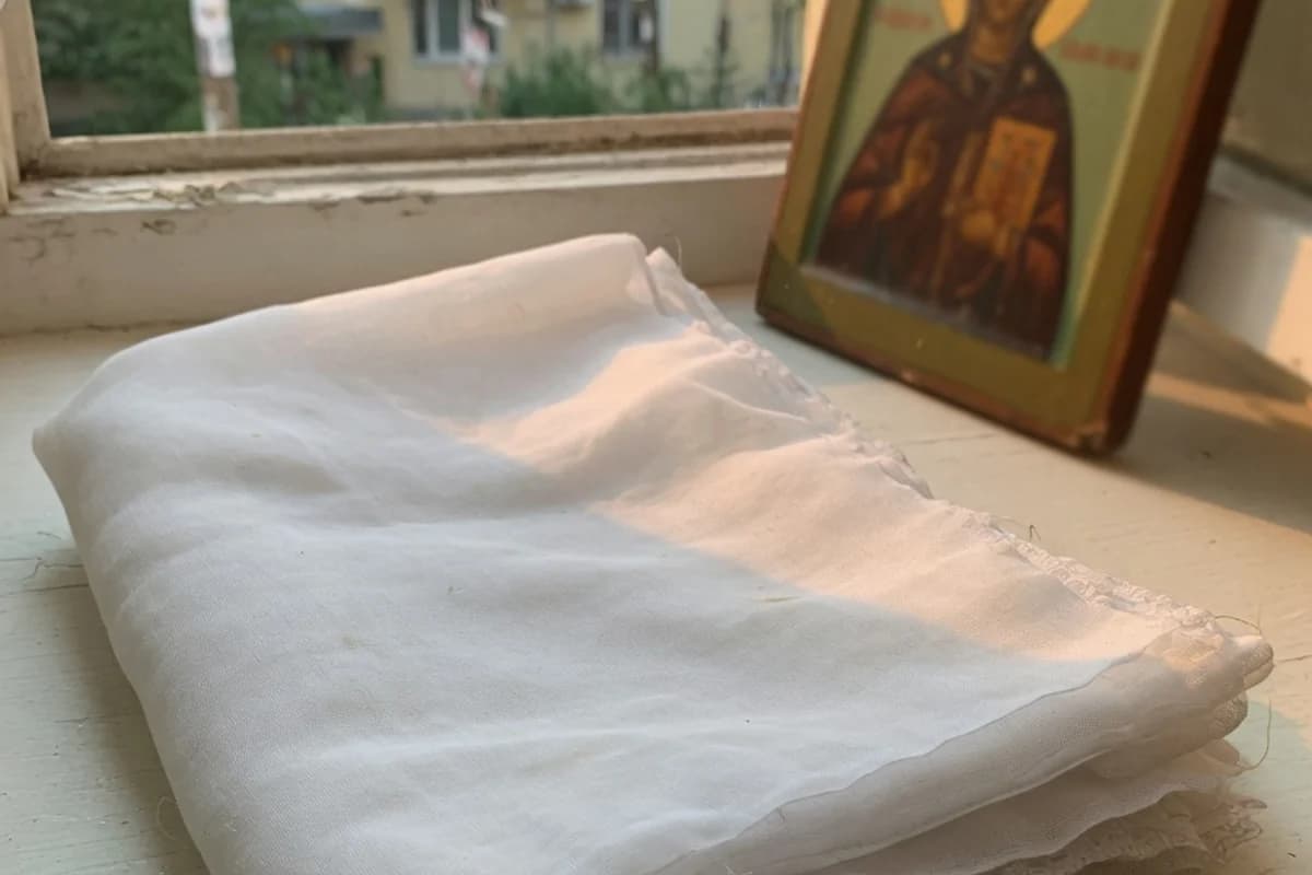 Folded white veil beside a small icon, no readable details, Sector 6, Bucharest