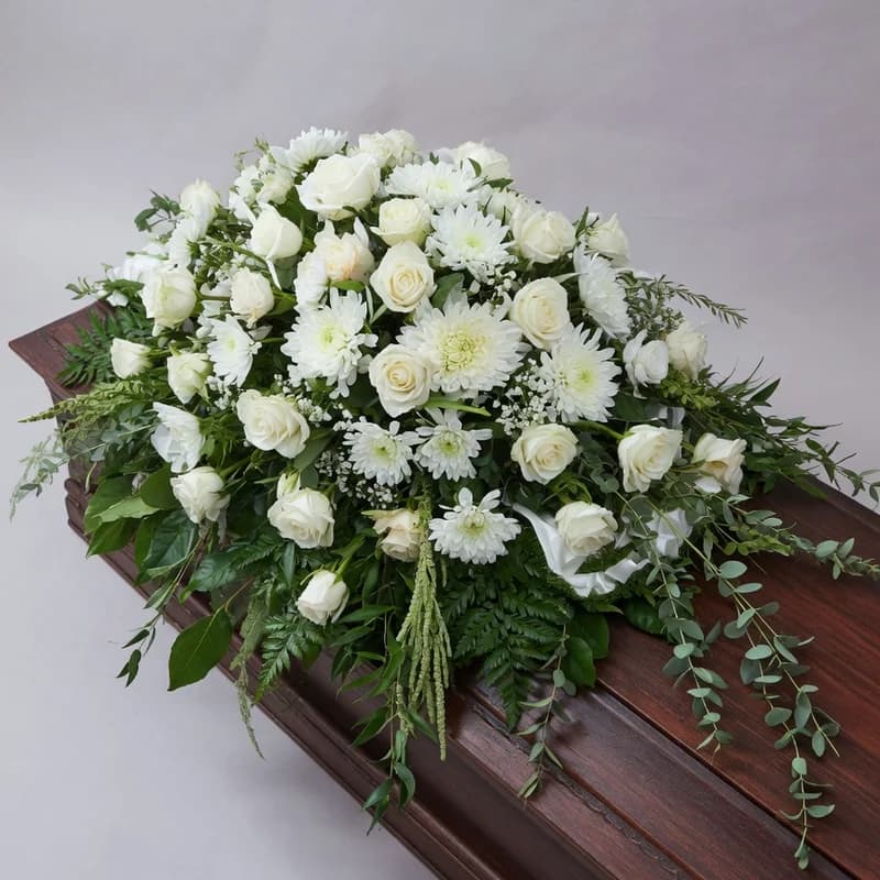 Aranjament floral amplu așezat pe capacul sicriului