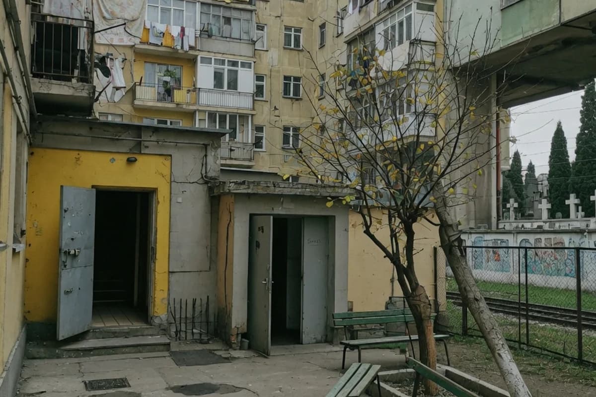 Curte interioară de bloc cu copaci și bănci vechi, Sectorul 4, București