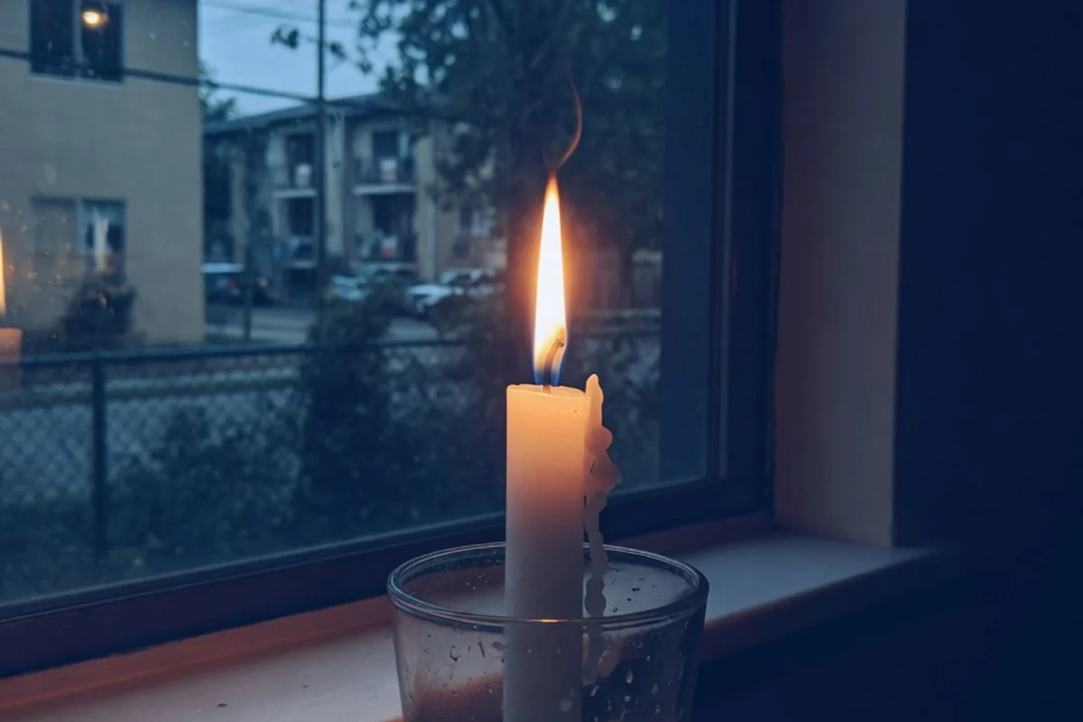 Lumânare albă aprinsă pe fundal albastru închis, Sectorul 6, București