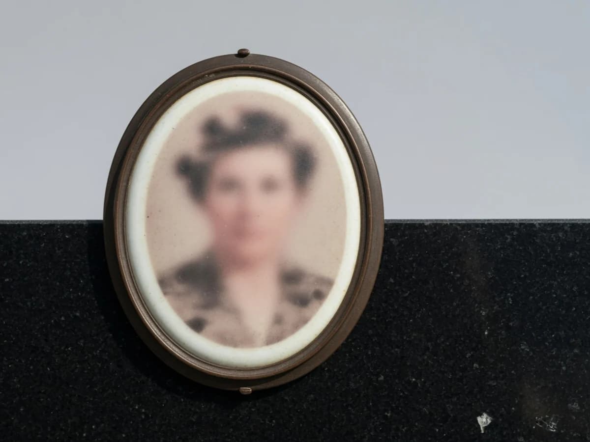 Medalion de fotoceramică oval (portret generic estompat, nedeslușit), ramă bronz, pe granit negru
